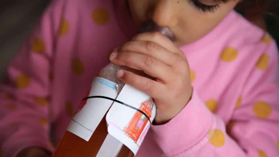 Trip to the apple farm: A child tries the first sip of apple juice at MILK. Mahlzeit's first sip of apple juice 