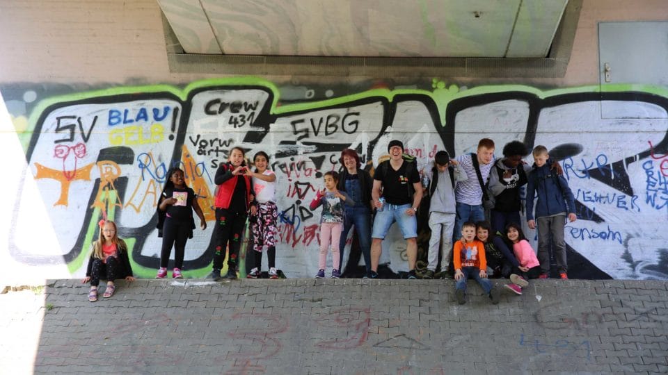 Bee nature trail: Meal campaign with the beekeepers. Group photo in front of a graffiti. 