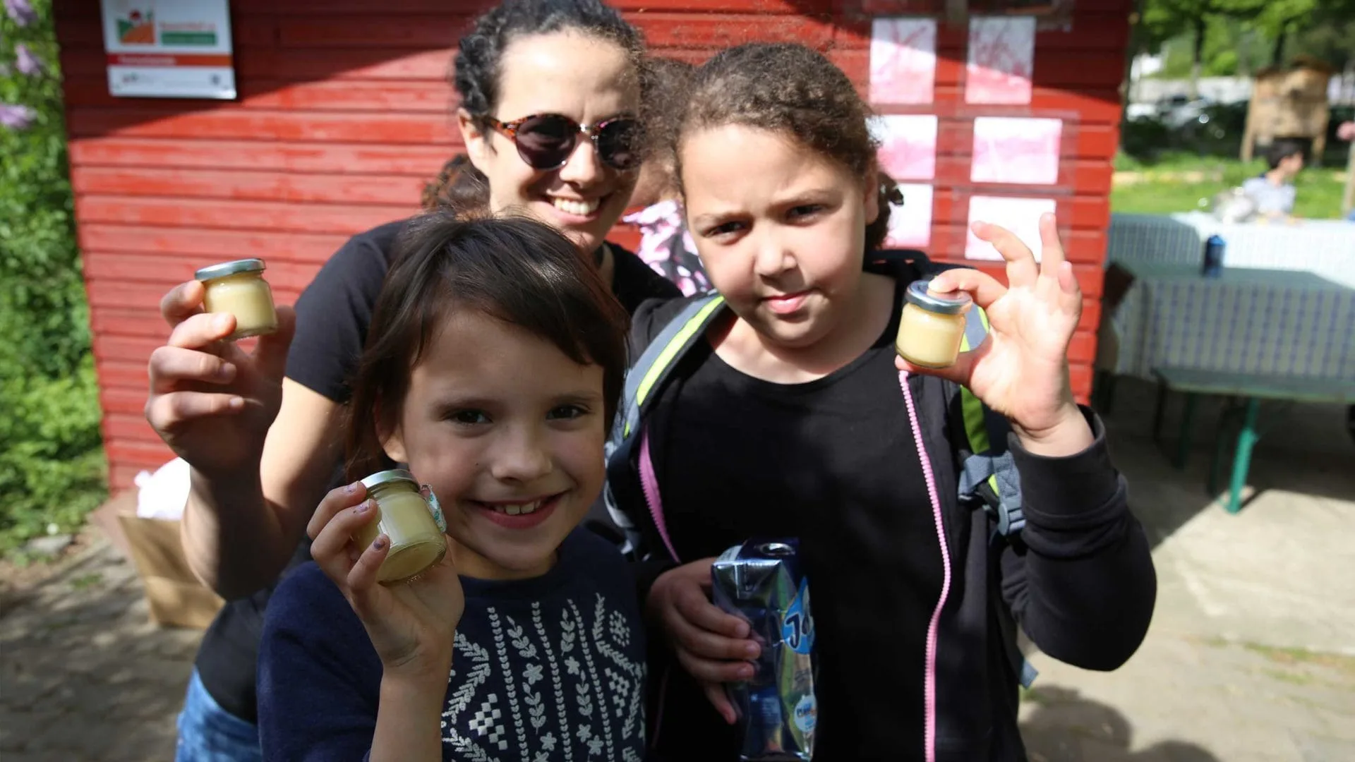 Bienenlehrpfad: Aktion Mahlzeit bei den Imkern. Die Kinder Präsentieren stolz ihren Honig.
