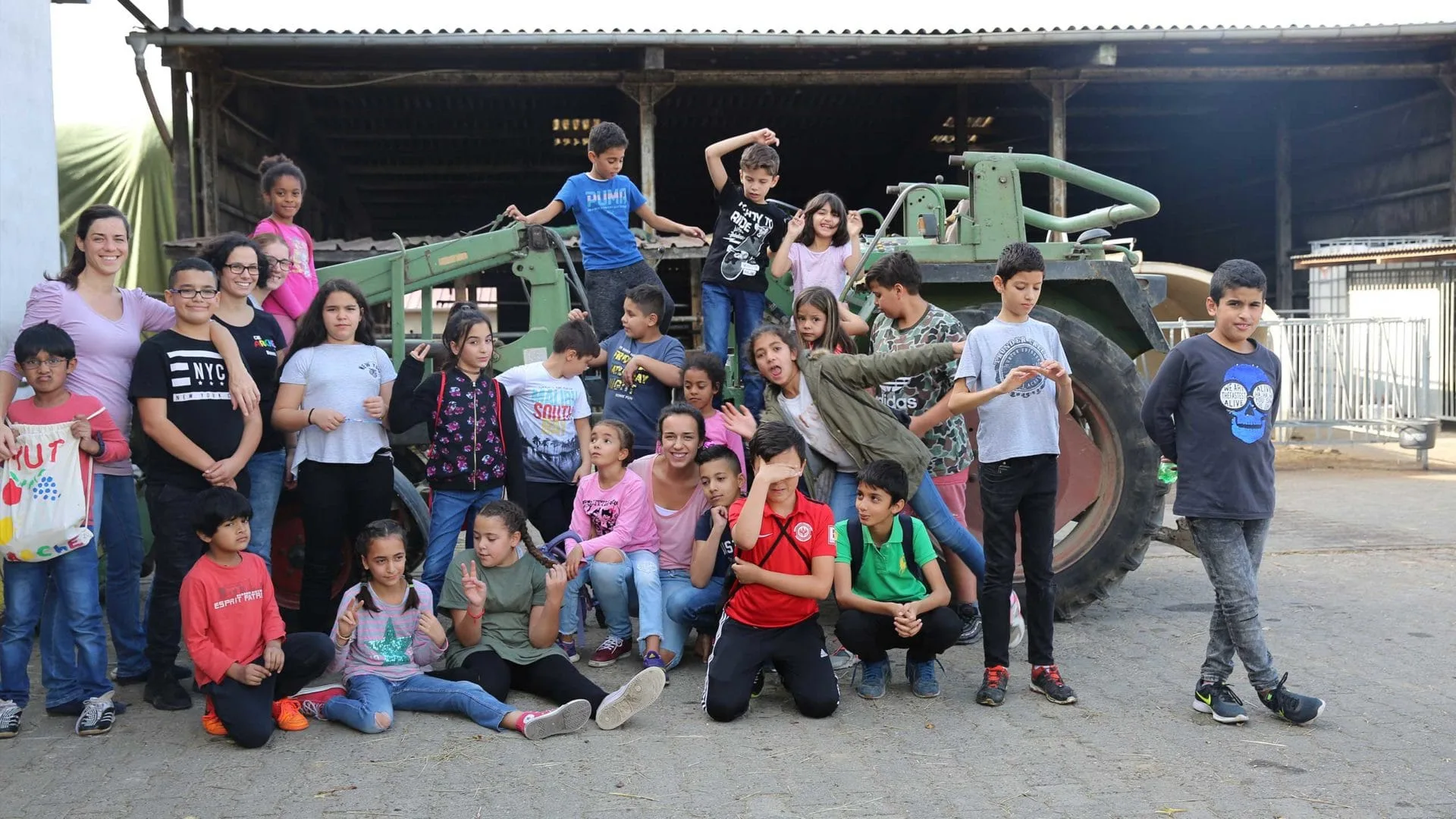 Aktion Mahlzeit auf dem Milchhof. Gruppenfoto auf einem Traktor.