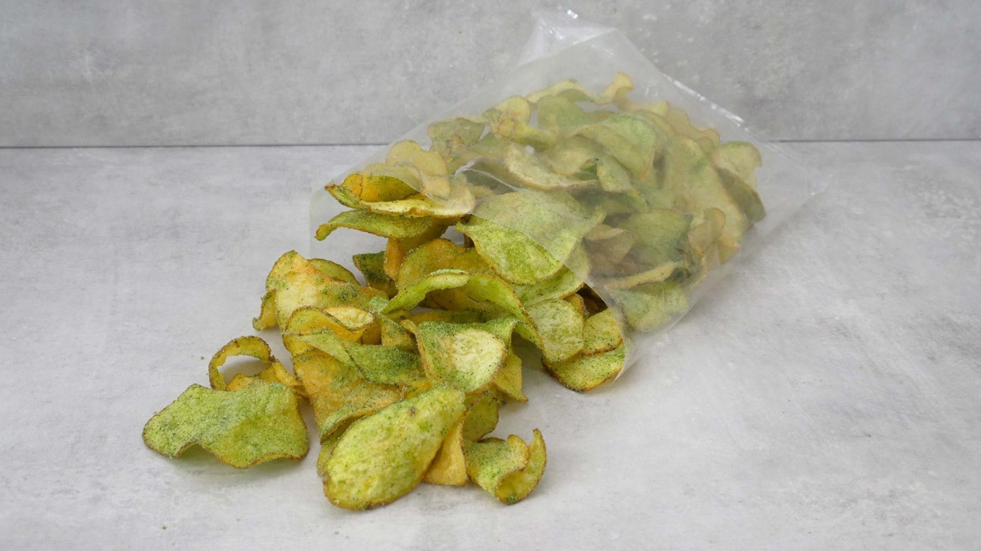 Chips with green dust in an open, transparent bag