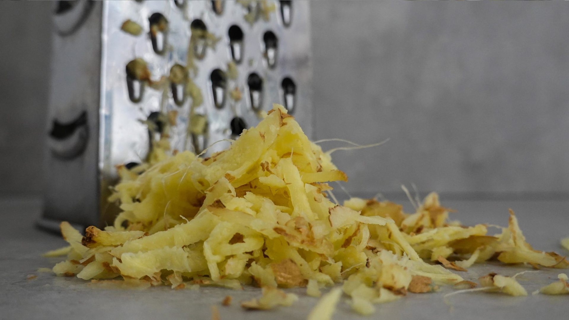 Grated ginger in front of a box grater