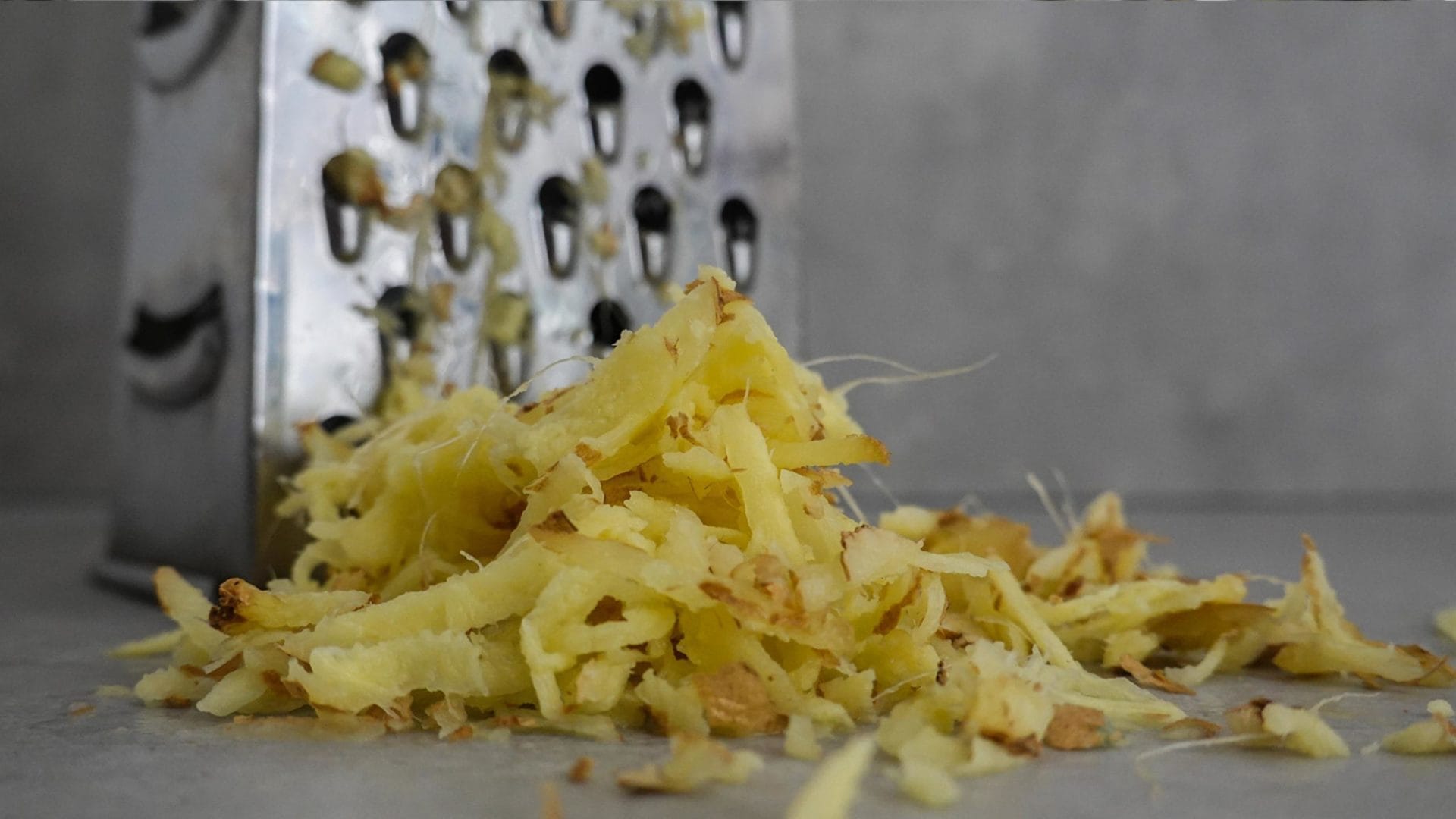 Grated ginger in front of a box grater