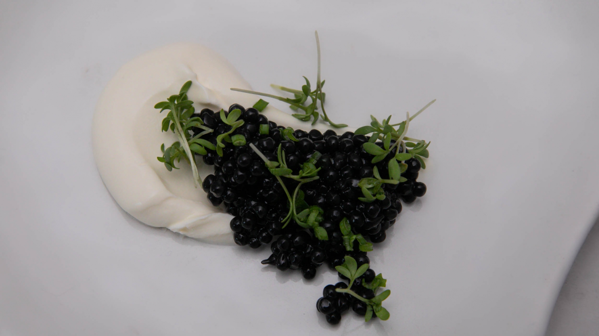 Vegan caviar and cress on sour cream