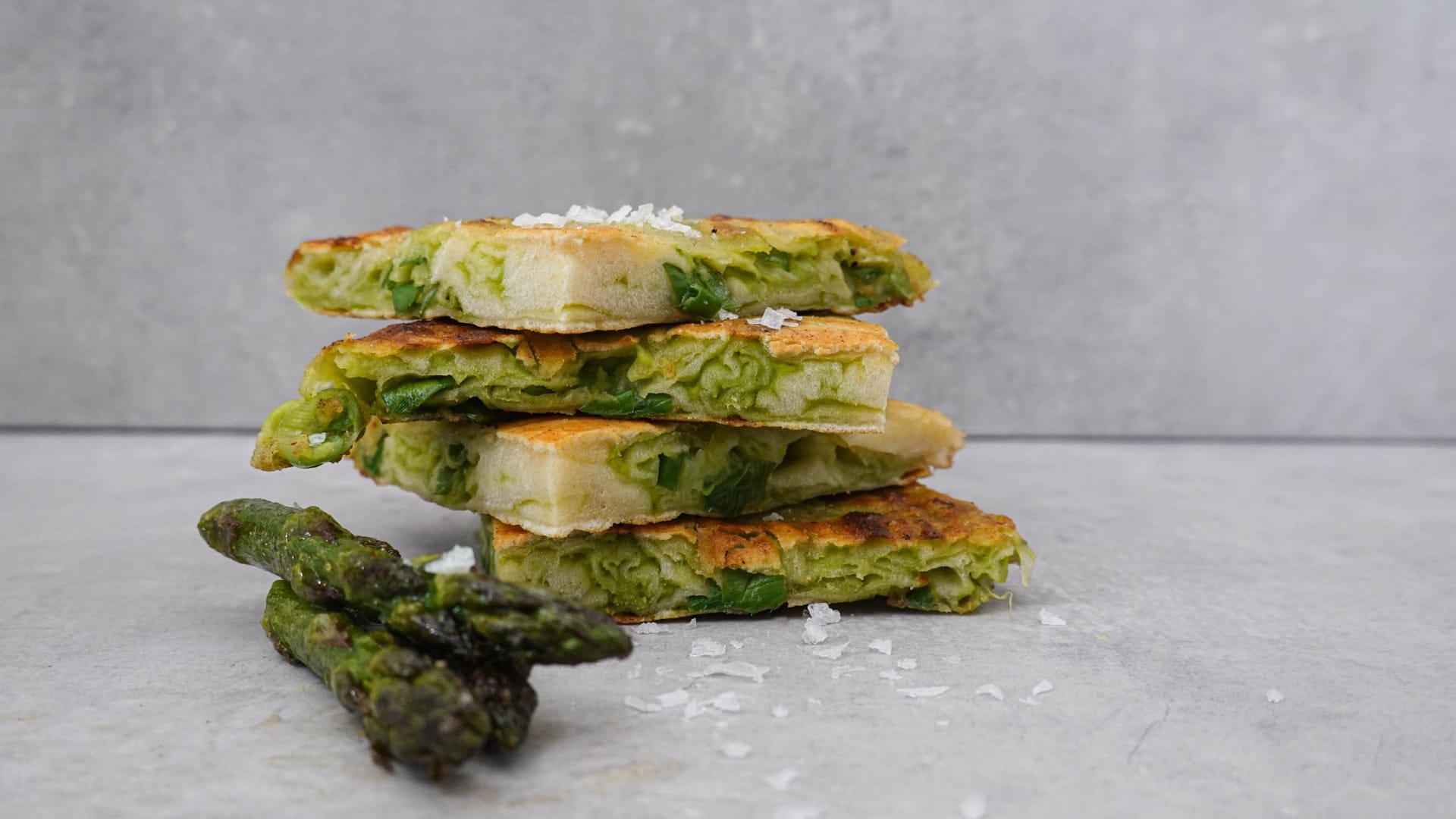 A pea pancake quartered with green asparagus