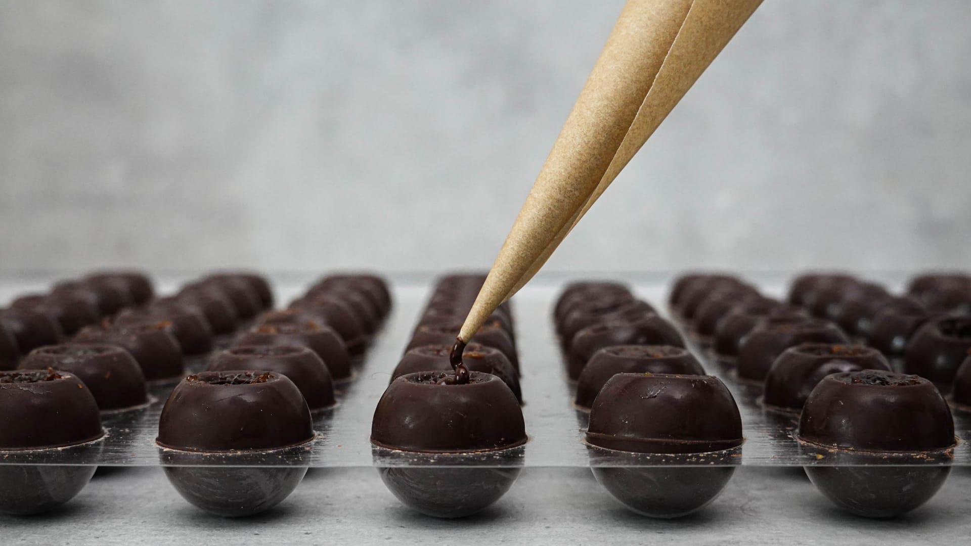 Chocolate hollow bodies in plastic form are sealed with chocolate