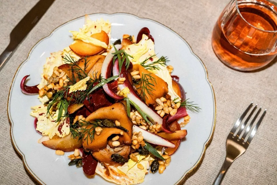 Plate with Verrano salad and herbs, served with a drink